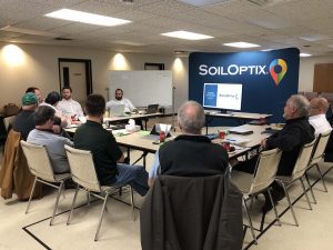 Group of people at conference table with the SoilOptix® backdrop