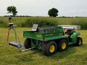 John Deere Gator and equipment in field