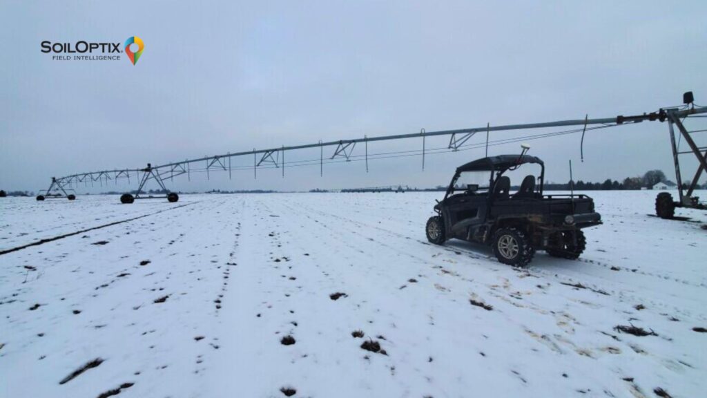 A SoilOptix® field vehicle parked beside a center-pivot irrigation system during winter soil surveying on a snow-covered agricultural field, highlighting winter soil management and early spring preparation.